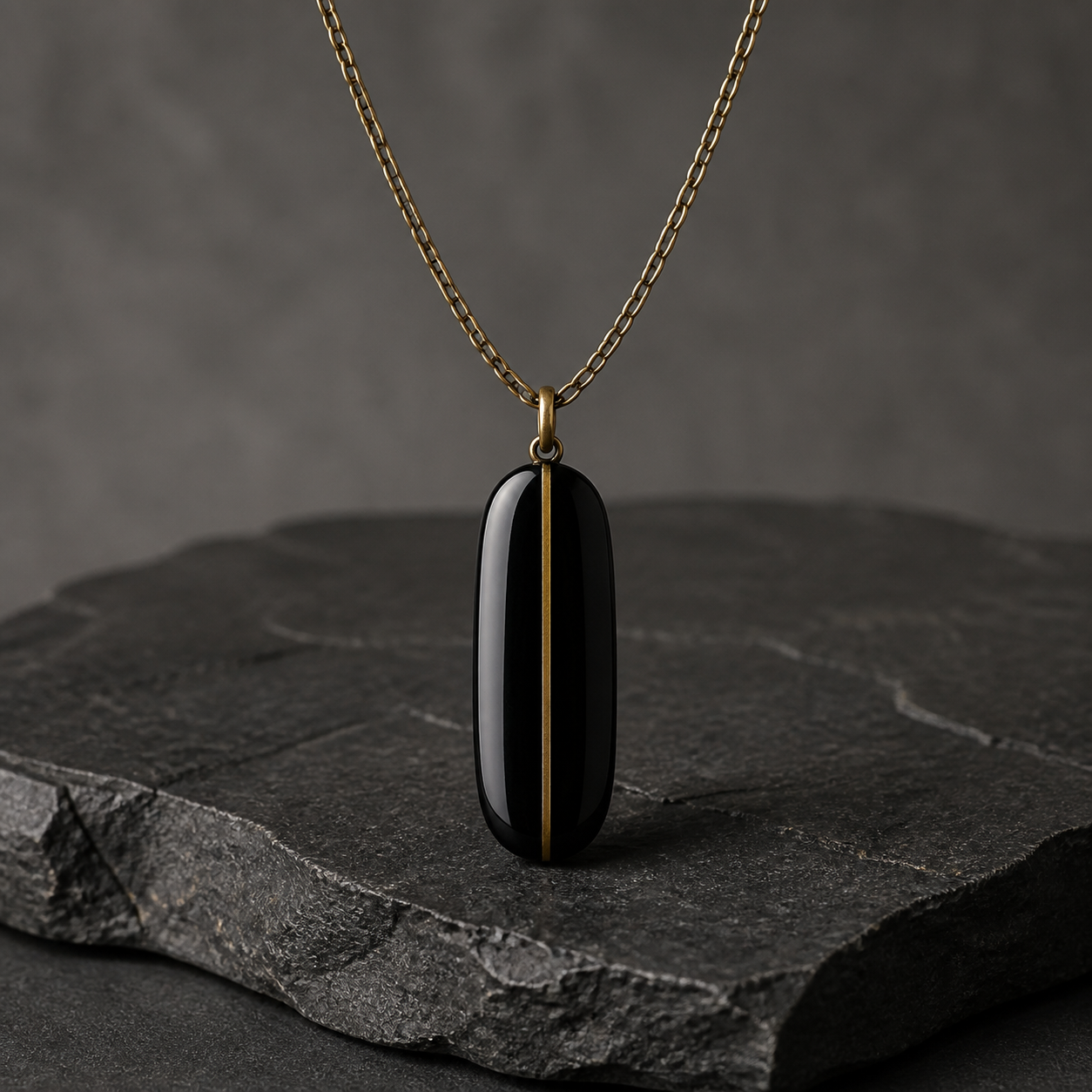 Polished black obsidian pendant with a narrow gold-tone meridian